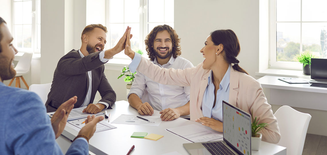 Overjoyed diverse employees give high five celebrate business success